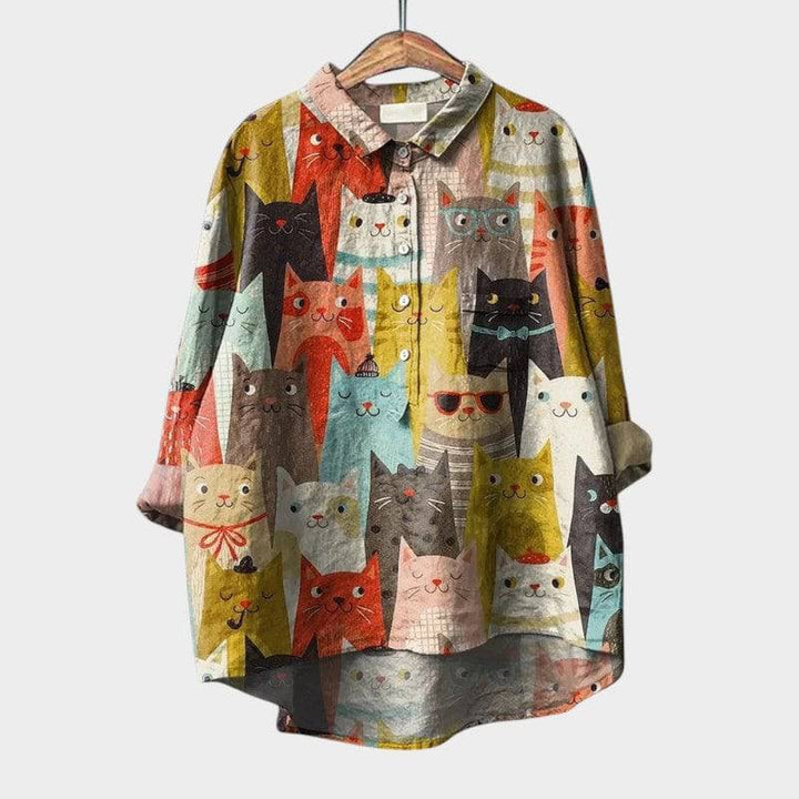 Emma & Rose Cape Town Milla™ elegant blouse with long sleeves and button front, displayed on a hanger.