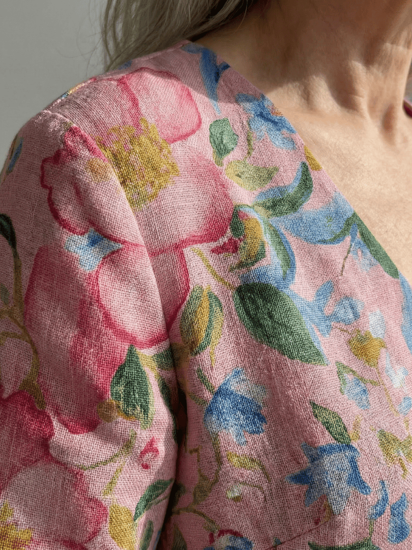 Julien™ Form Floral Midi Dress by Emma & Rose Cape Town displayed on a hanger with vibrant floral patterns and flowing fabric.
