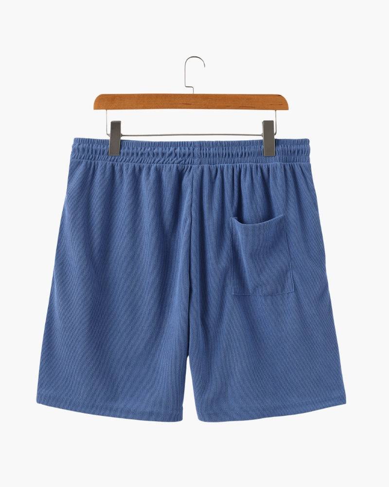 Emma & Rose Manhattan Dean Beachstride Shorts in lightweight fabric, shown folded with tropical print and drawstring waist.