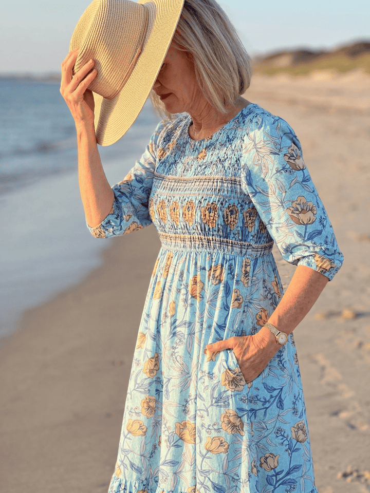 Halia Meadow Gather Midi Dress by Emma & Rose Cape Town, featuring a flowy fabric and floral pattern, worn by a model outdoors.