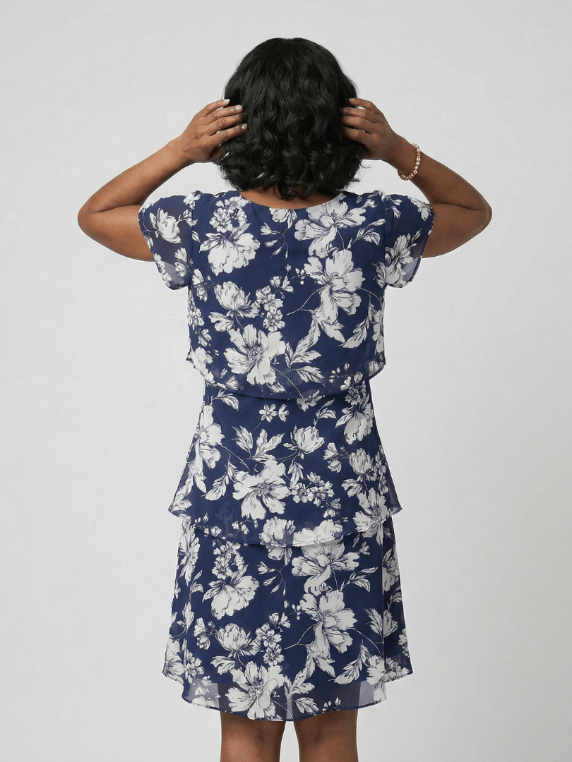 Thea™ floral knee-length dress by Emma & Rose Cape Town, showcasing a flowy fabric with vibrant floral patterns and a fitted waist.