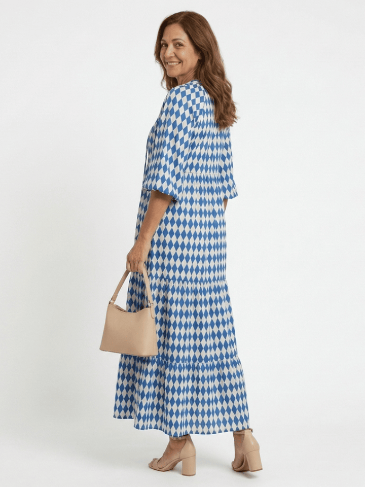 Elodie™ Print Tiered Midi Dress by Emma & Rose Cape Town, featuring a colorful floral pattern and tiered flowing fabric.