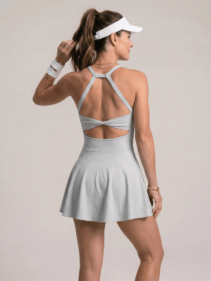 Emma & Rose Cape Town Zerelle™ strappy back tennis dress with fitted silhouette and athletic design, shown on a model.