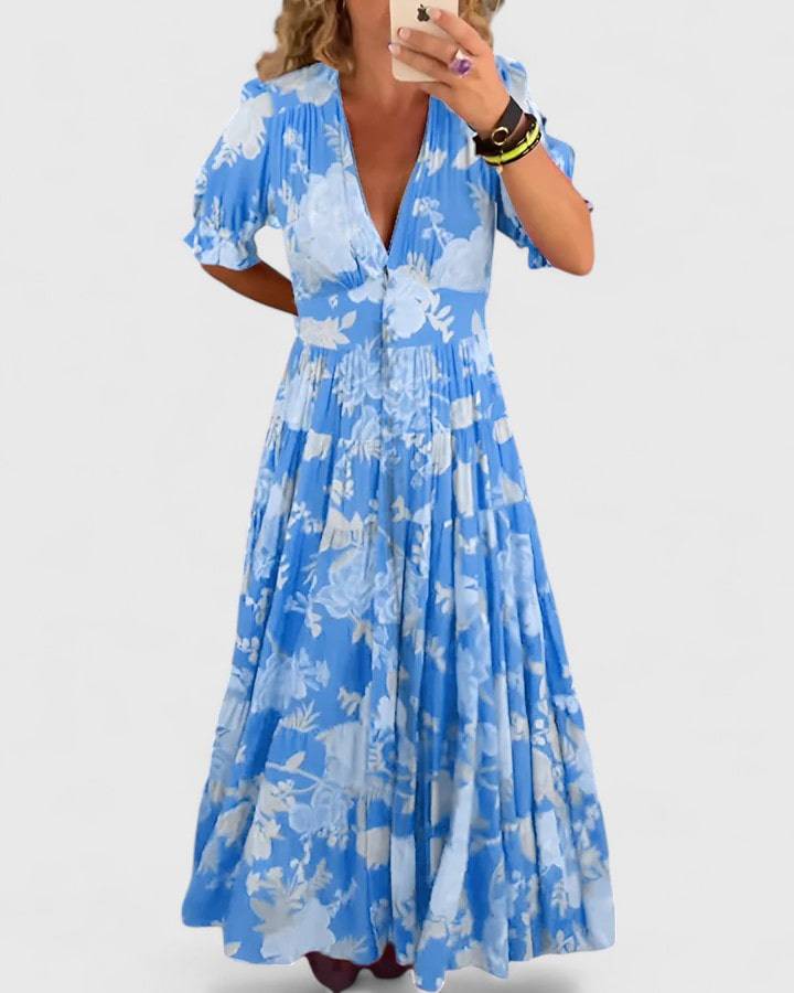 Elegant floral V-neck dress by Minelda™ from Emma & Rose Cape Town, featuring a fitted silhouette and vibrant flower patterns.
