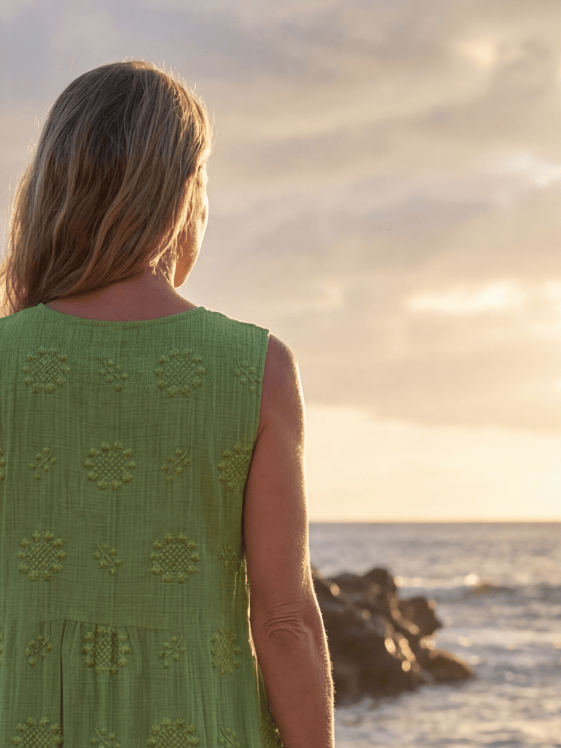 Kapua™ Garden Texture Midi Dress by Emma & Rose Cape Town, featuring floral print and flowing fabric, displayed on a hanger.