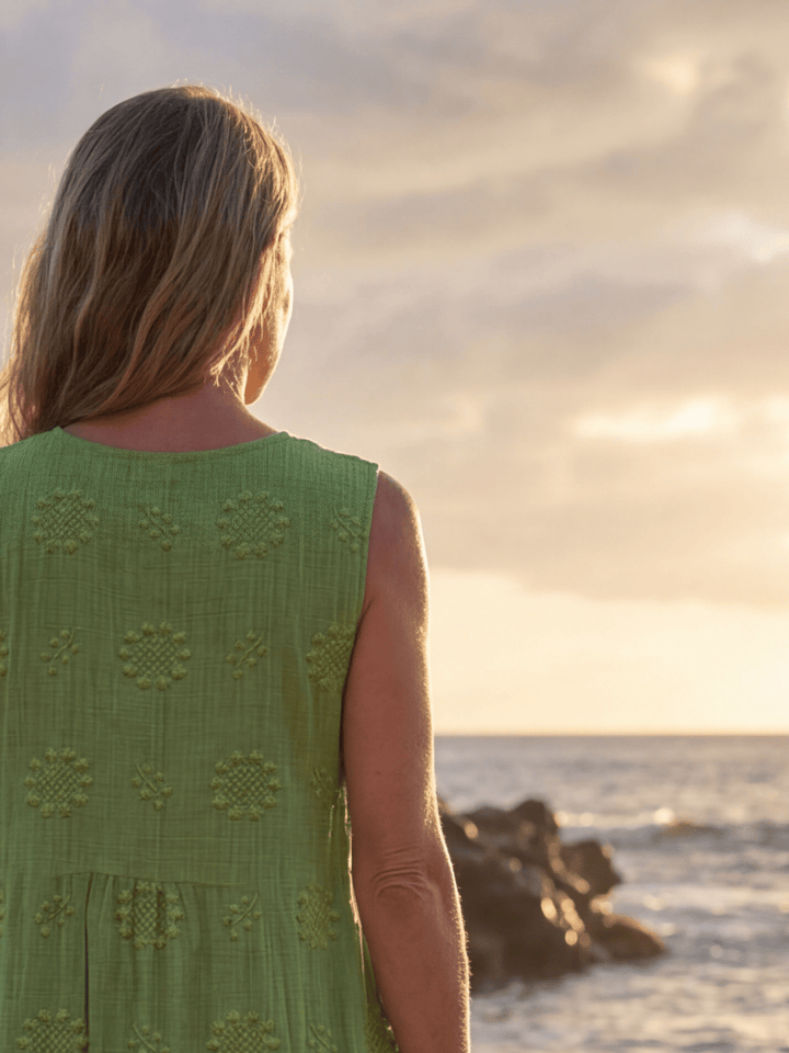 Kapua™ Garden Texture Midi Dress by Emma & Rose Cape Town, featuring floral print and flowing fabric, displayed on a hanger.