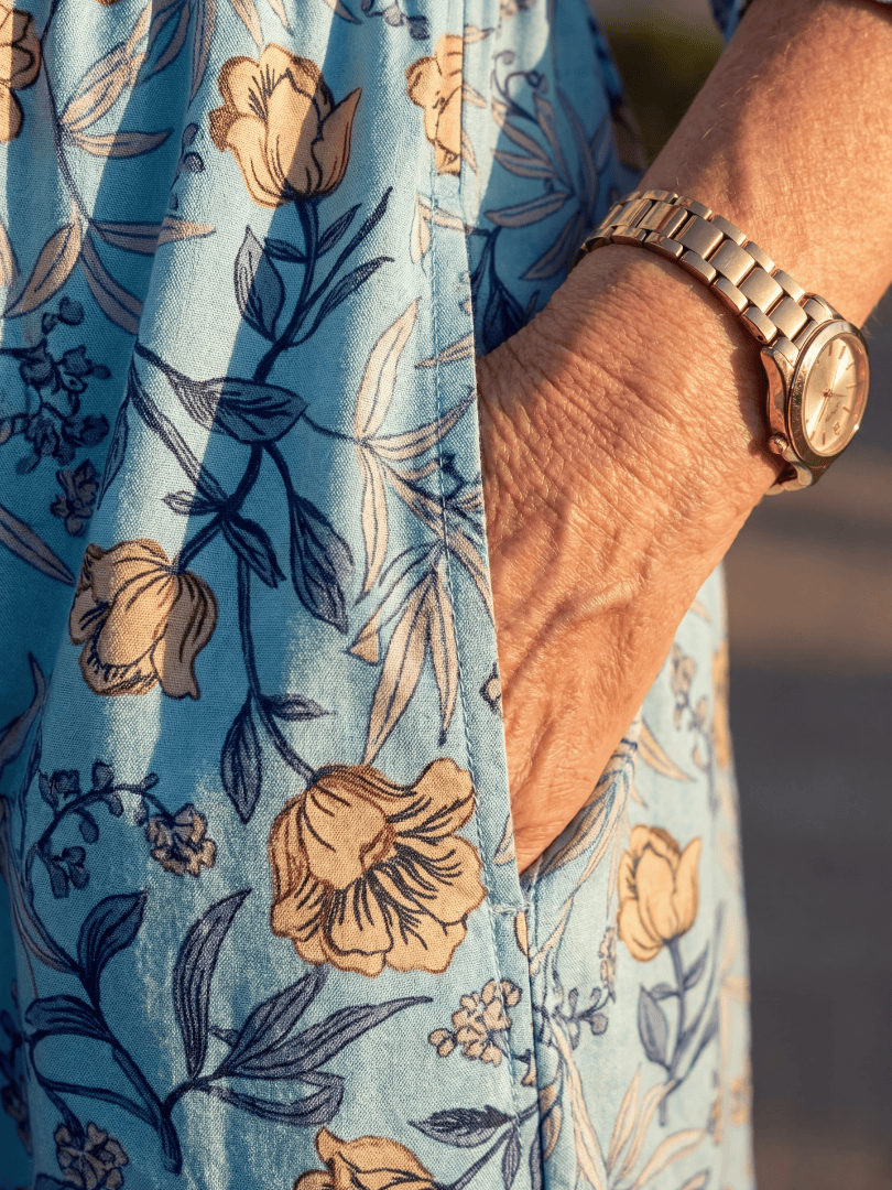 Halia Meadow Gather Midi Dress by Emma & Rose Cape Town, featuring a flowy fabric with floral patterns and a fitted waist.