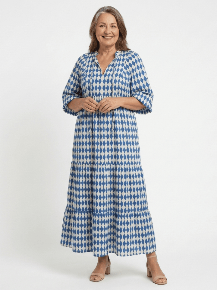 Emma & Rose Cape Town Elodie™ Print Tiered Midi Dress with floral pattern and flowing fabric, shown on a hanger.