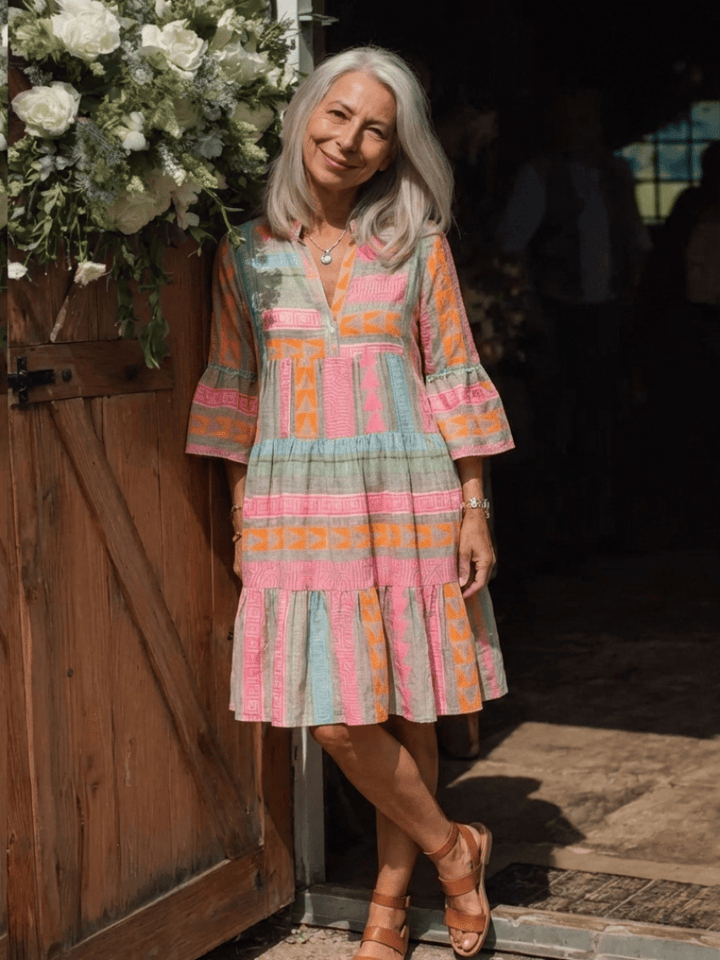 Maelle™ tiered knee-length dress by Emma & Rose Cape Town, flowing fabric with layered design and short sleeves.