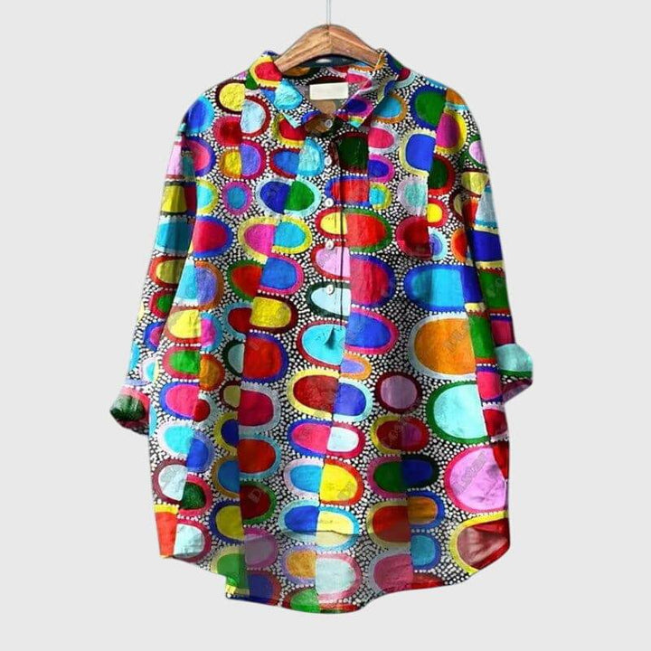 Emma & Rose Cape Town Linnea™ elegant blouse with long sleeves and ruffled details, displayed on a hanger.