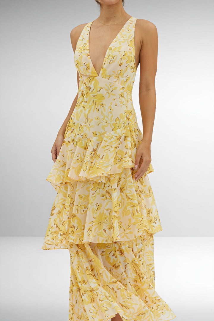 Floral print dress with deep V-neck by Emma & Rose Cape Town, featuring vibrant blossoms and flowing fabric.