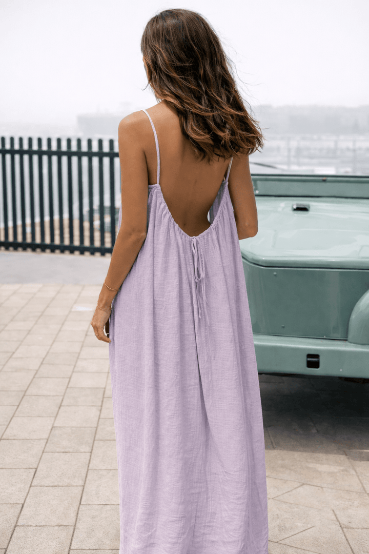 Velle Noir Mora™ backless maxi dress by Emma & Rose Cape Town displayed on a hanger with flowing fabric and elegant silhouette.