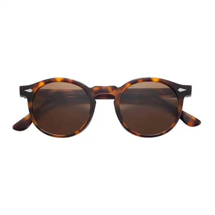 Emma & Rose Manhattan Skyler™ timeless tinted sunglasses with rounded frames and dark tinted lenses on a white background.