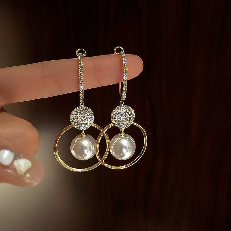 Elegant pearl earrings from Kadita™ by Emma & Rose Cape Town featuring classic white pearls and silver hooks.