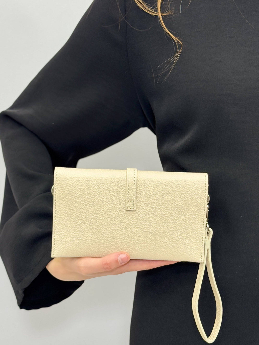 Emma & Rose Cape Town Yael™ leather clutch bag strap showing a sleek brown leather design with metal hardware.