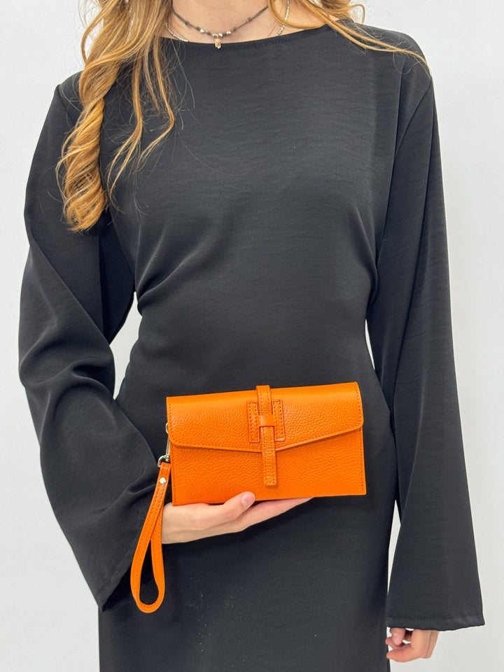 Emma & Rose Cape Town Yael™ leather clutch bag strap attached to a black clutch, showcasing the stylish accessory with leather details.