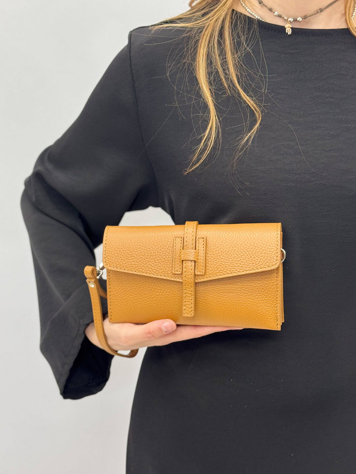 Emma & Rose Cape Town Yael™ leather clutch bag strap with adjustable design and tan leather finish, shown on a white background.