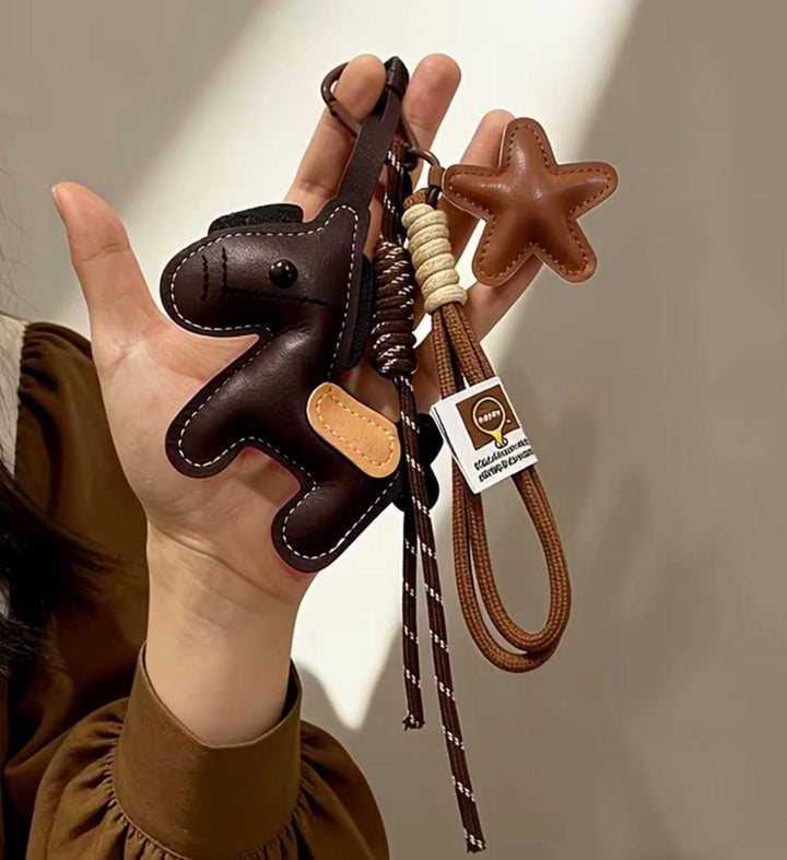 Emma & Rose Cape Town Anneke pony-shaped bag charm attached to a stylish borse, showcasing playful and colorful design.