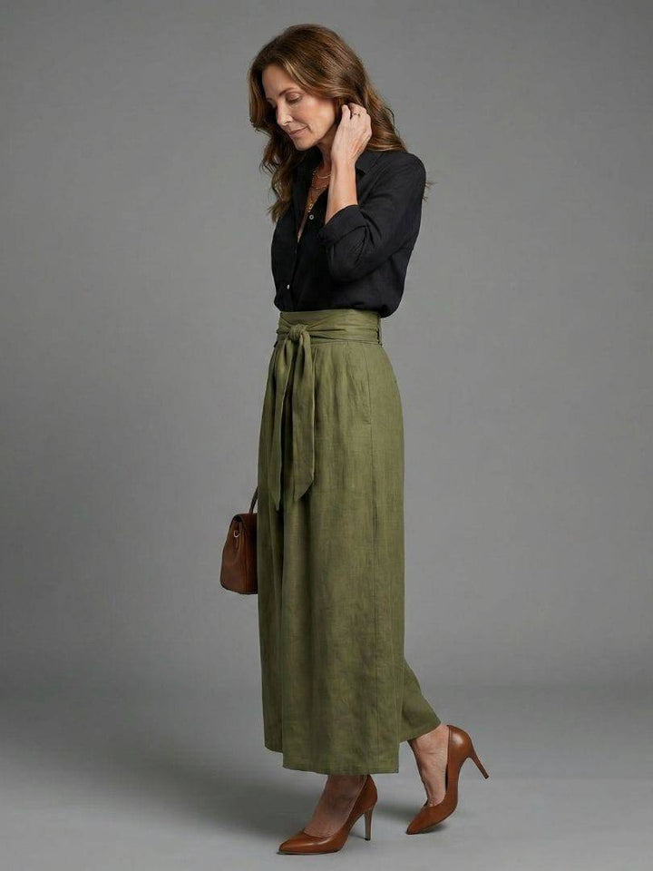 Olive green Vera™ midi skirt by Emma & Rose Cape Town, displayed on a hanger, showcasing its flowy fabric and midi length.