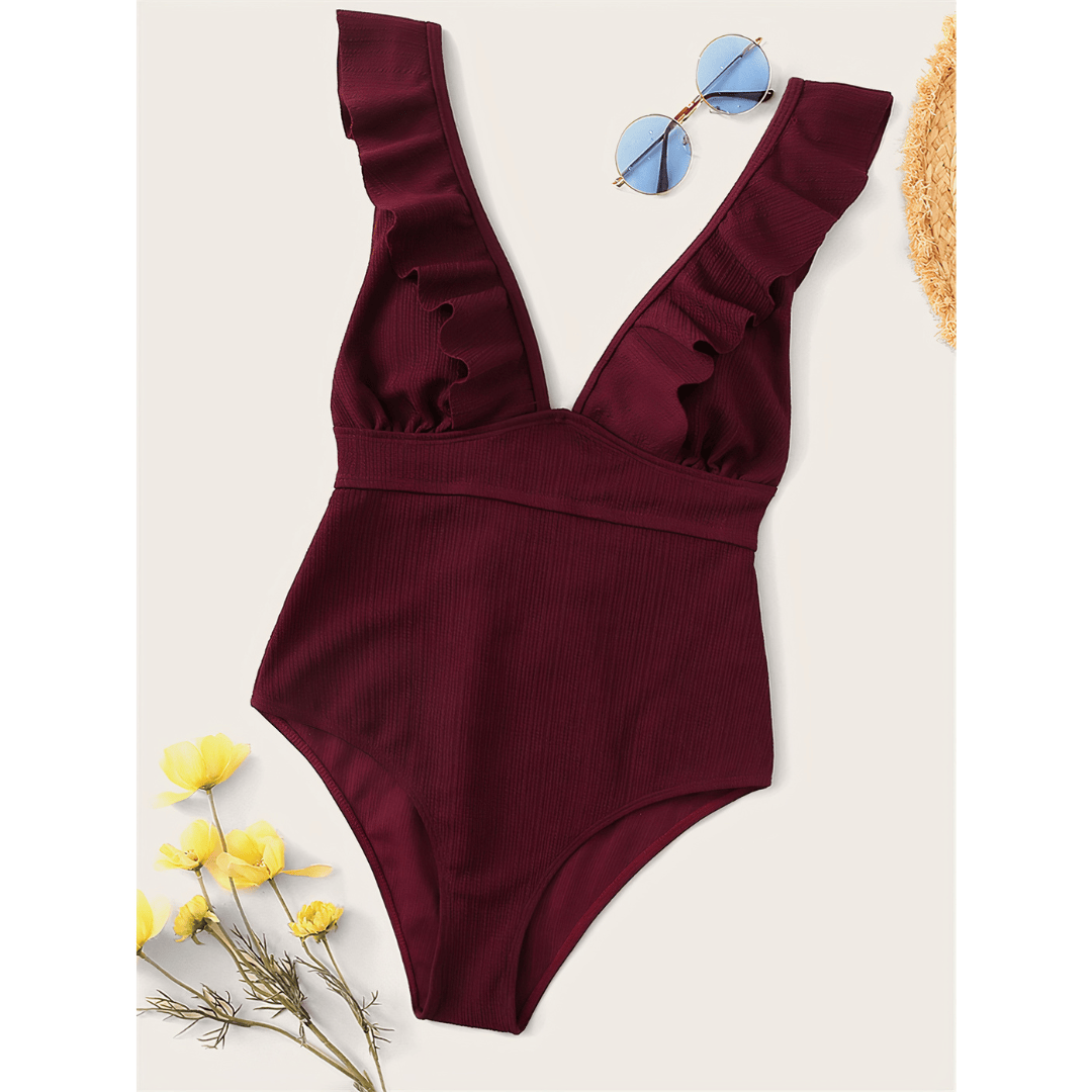 Olivia™ Mirage Swimsuit by Emma & Rose Manhattan displayed on a hanger with a vibrant, colorful pattern and sleek design.