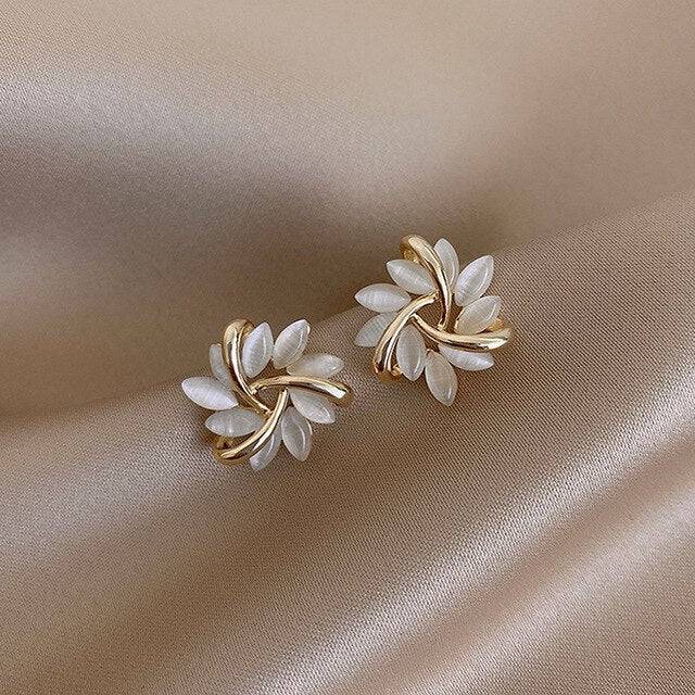 Elegant Bloom™ opal earrings with circular hook design, featuring polished white opals in a stylish jewelry presentation.