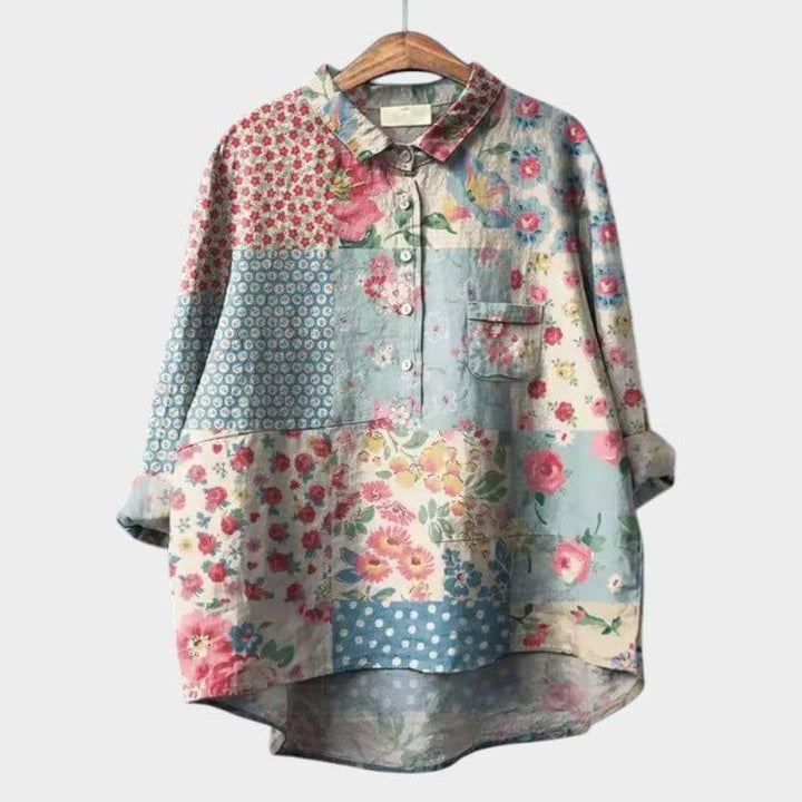 Ronja™ elegant blouse by Emma & Rose Cape Town, light-colored fabric with stylish collar and button details, displayed on a hanger.