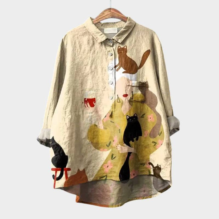 Elegant Saga™ blouse by Emma & Rose Cape Town, featuring stylish fabric and a sophisticated design, displayed on a hanger.