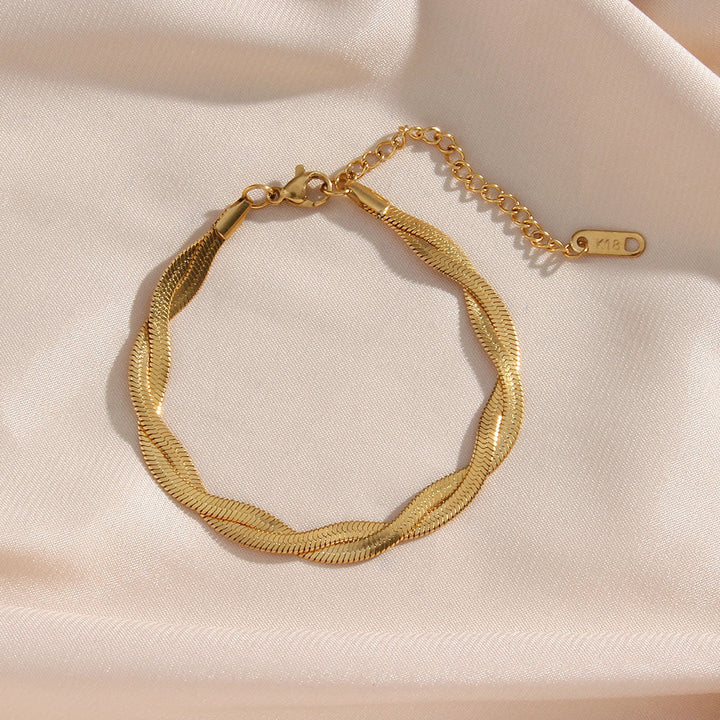 Emma & Rose Cape Town Madiorelle twisted 18k gold armband with elegant, intertwined design on a white background.