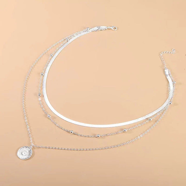 Emma & Rose Cape Town Triple Radiant Necklace featuring layered gold chains and sparkling pendant on a white background.