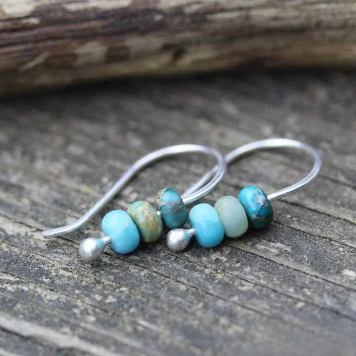 Turquoise and pearl earrings by Emma & Rose Cape Town featuring elegant dangle design with vibrant turquoise stones and white pearls.