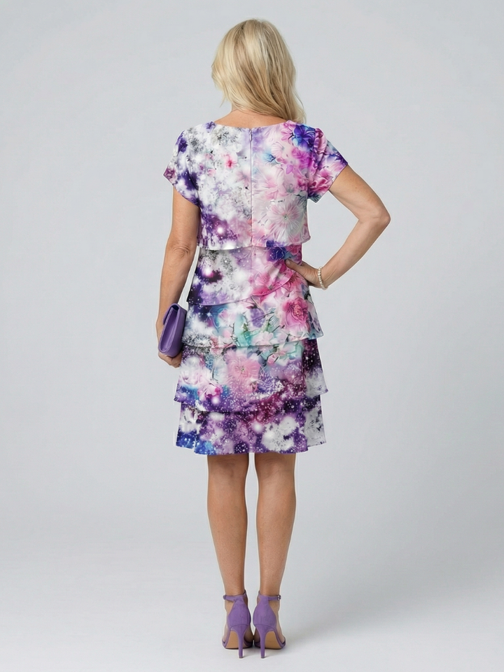 Emma & Rose Cape Town Zaya Bloom knee-length floral dress with vibrant flower pattern and elegant fit on model.