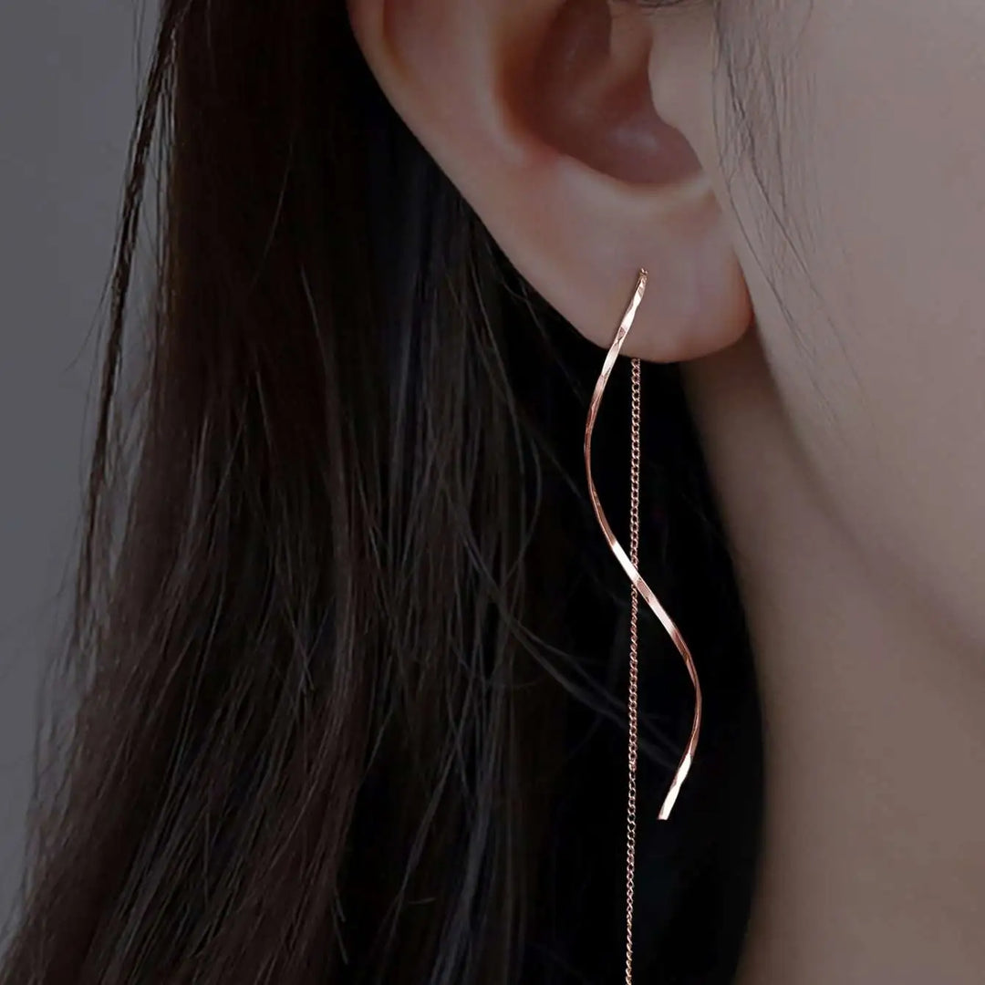 Emma & Rose Cape Town Phaedra™ gold long earrings with wavy design, featuring elegant, flowing metalwork.