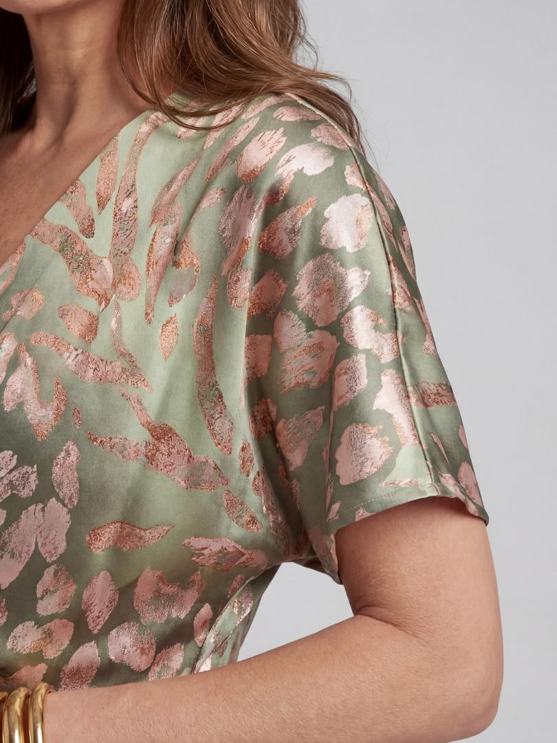 Emma & Rose Cape Town Coralie™ twist waist midi dress in green, showing a fitted silhouette and elegant design with a twist detail at the waist.