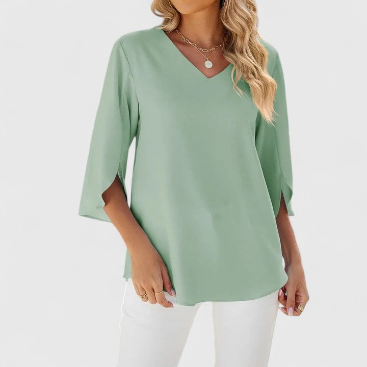 Green Debby™ elegant blouse by Emma & Rose Cape Town, shown on a hanger with detailed fabric and stylish design.
