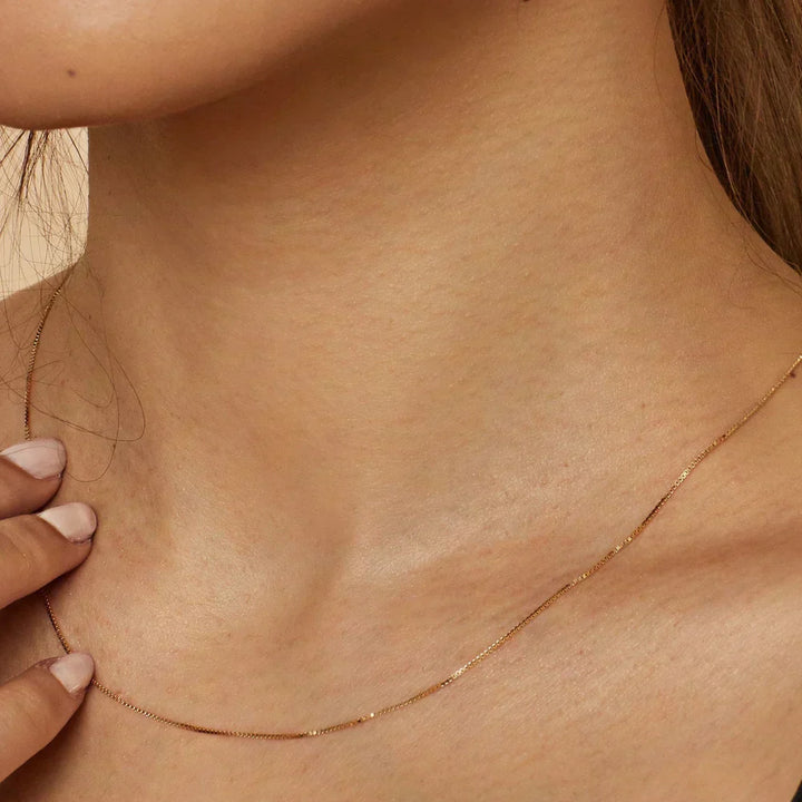 Emma & Rose Cape Town Clarionne™ 18K gold necklace featuring a delicate chain and elegant pendant, styled for sophisticated looks.