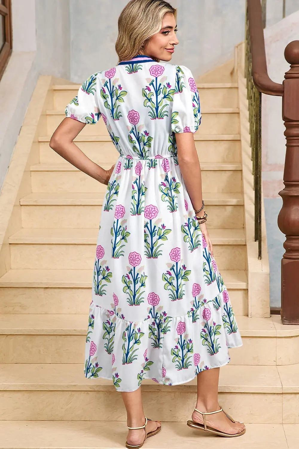 White floral midi dress by Emma & Rose Cape Town featuring ruffle hem and colorful neckline detail.