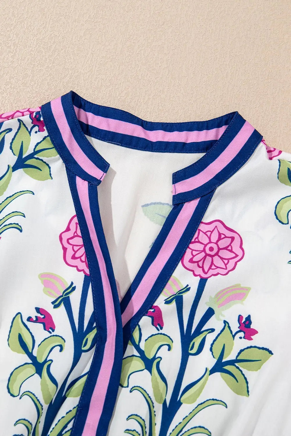 White floral midi dress by Emma & Rose Cape Town with ruffle hem and colorful neckline, perfect for elegant daytime wear.