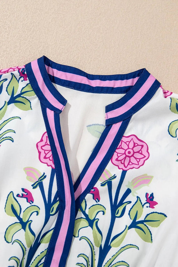 White floral midi dress by Emma & Rose Cape Town with ruffle hem and colorful neckline, perfect for elegant daytime wear.