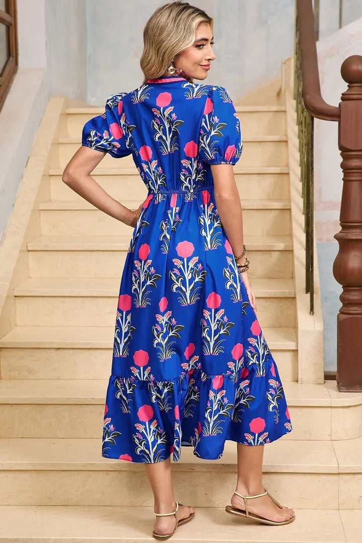White floral midi dress by Emma & Rose Cape Town featuring ruffle hem and colorful neckline details.