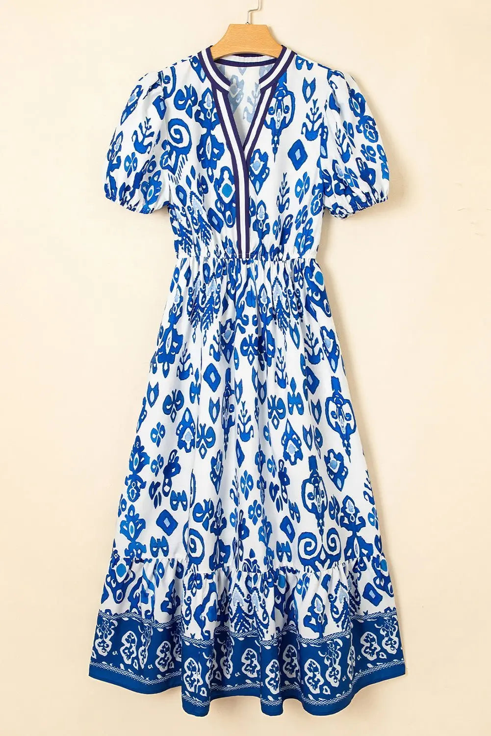 White floral midi dress by Emma & Rose Cape Town with ruffle hem and colorful neckline detail, perfect for elegant daytime wear.