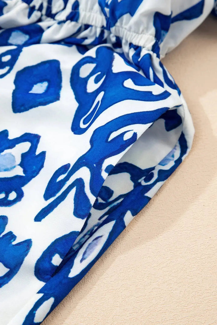 White floral midi dress with ruffle hem and colorful neckline by Emma & Rose Cape Town, perfect for summer occasions.