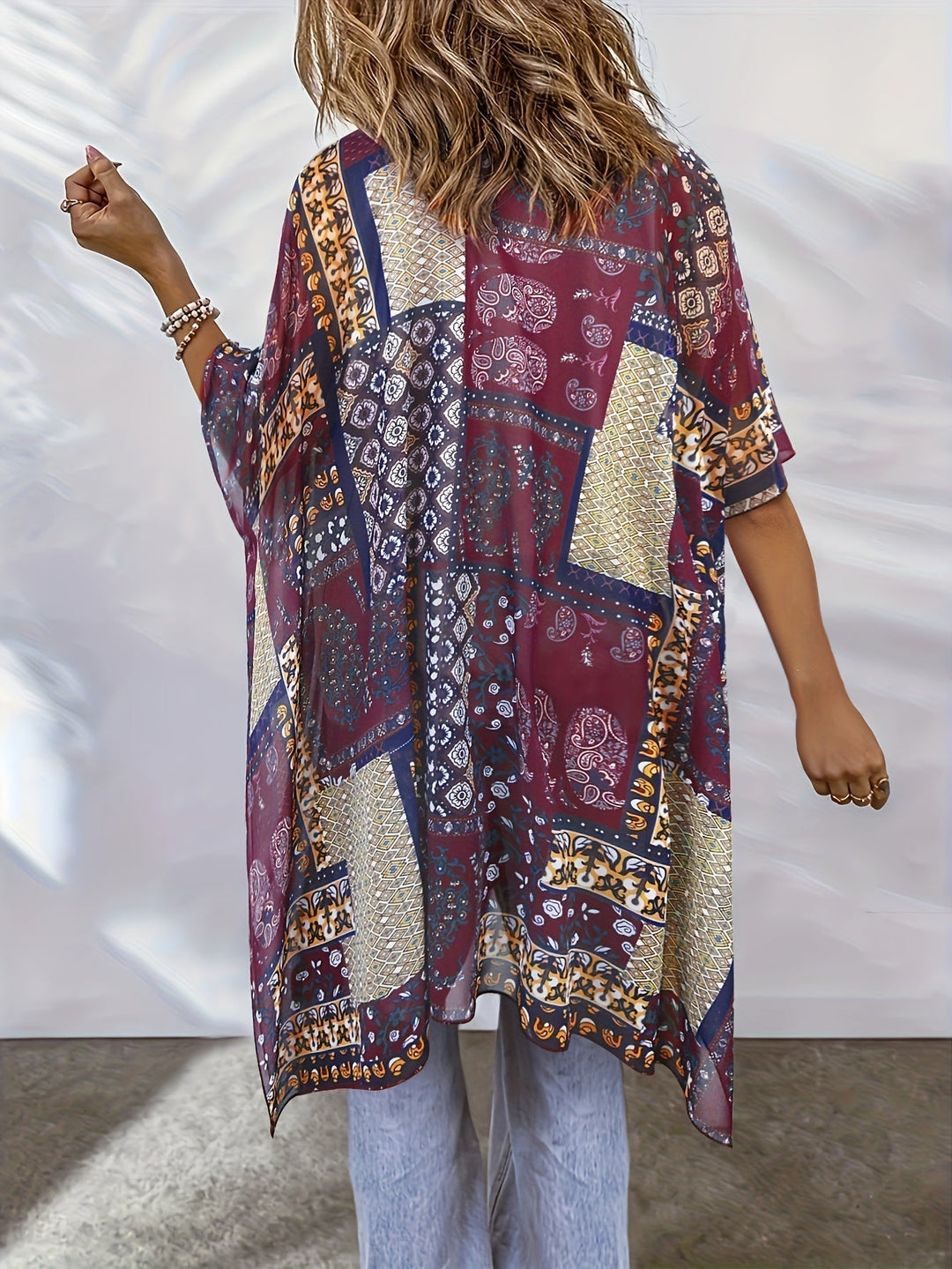Long bohemian-style Emma & Rose Cape Town Sanna™ cardigan with relaxed fit and intricate knit details, shown in a natural setting.
