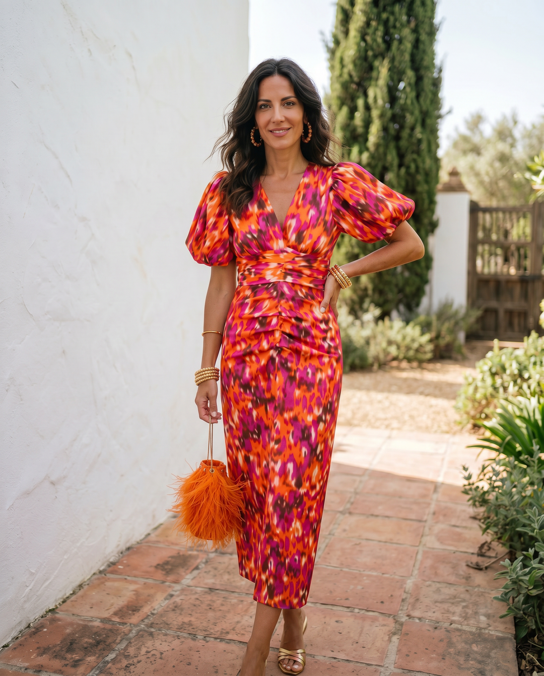 Orange printed Carla midi dress with puff sleeves by Emma & Rose Cape Town, shown on a model.