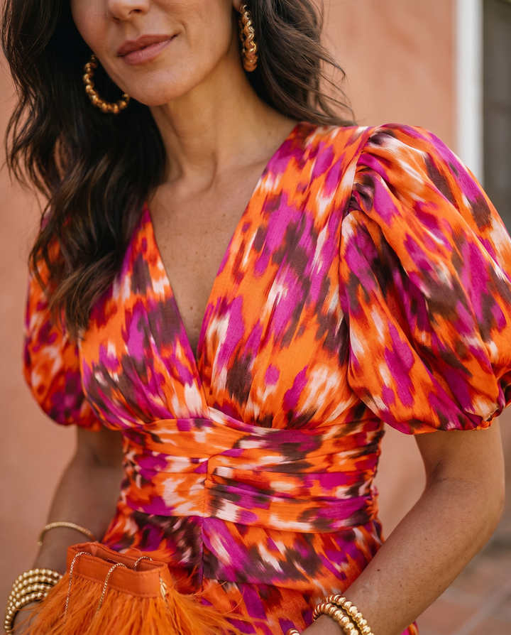 Emma & Rose Cape Town Carla printed midi dress with puff sleeves, showcased in vibrant orange fabric.