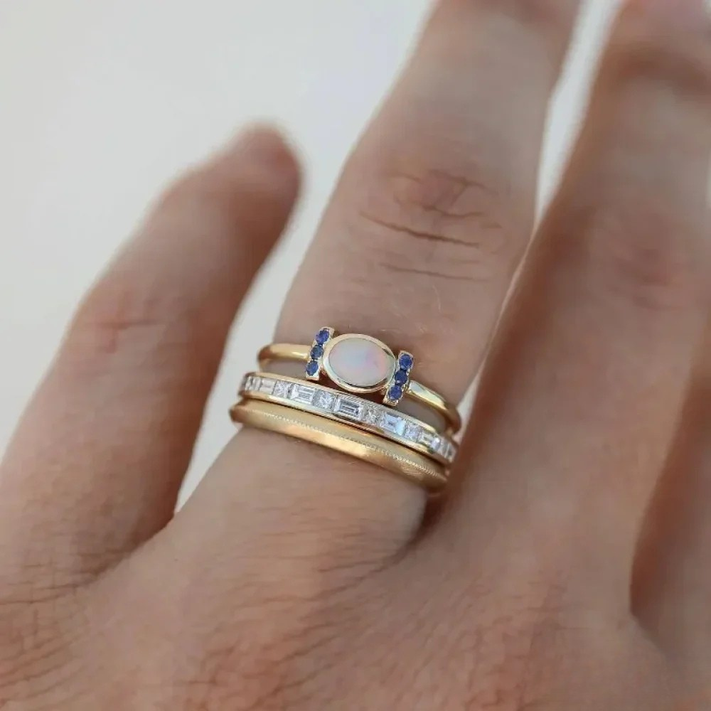 Set of vintage gold opal rings by Emma & Rose Cape Town, featuring multiple delicate rings with colorful opal stones.