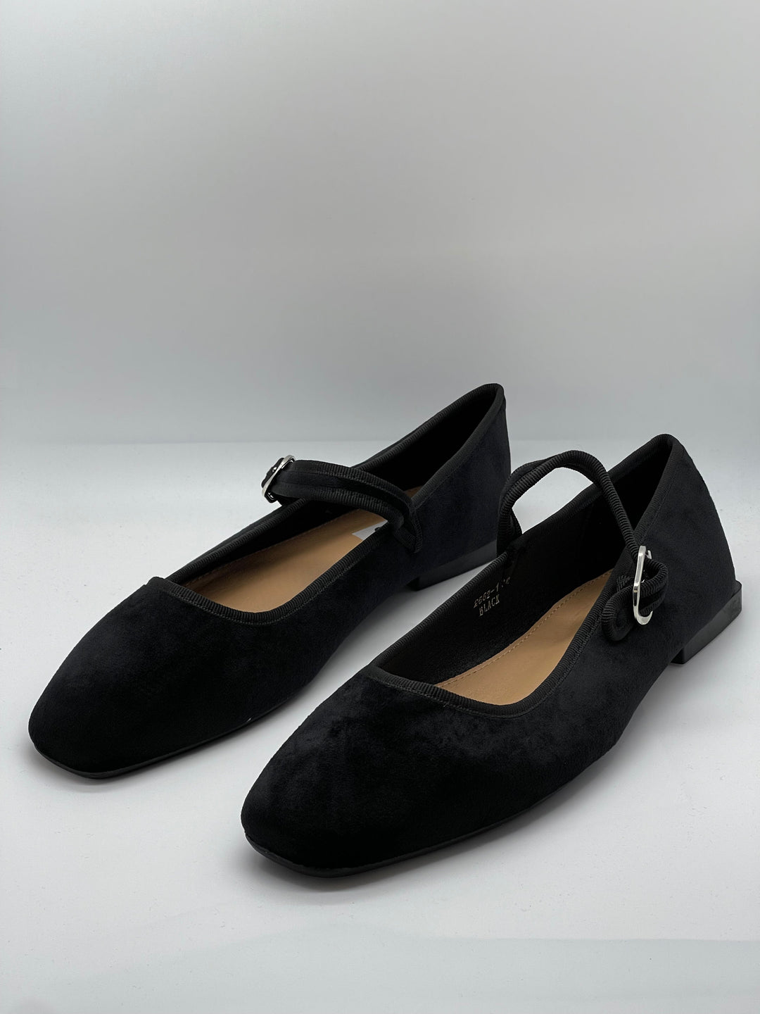 Black Yolande™ ballet flats with strap by Emma & Rose Cape Town, showcasing elegant slip-on shoes with a strap detail on a white background.