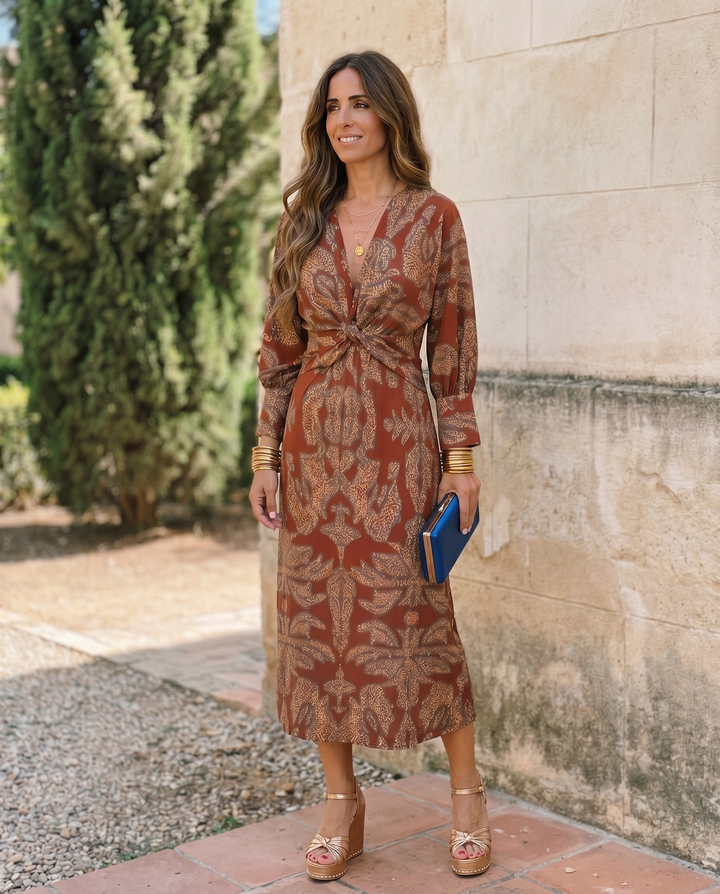 Silvia™ midi dress with vibrant print by Emma & Rose Cape Town, shown on a model in a candid fashion photo.
