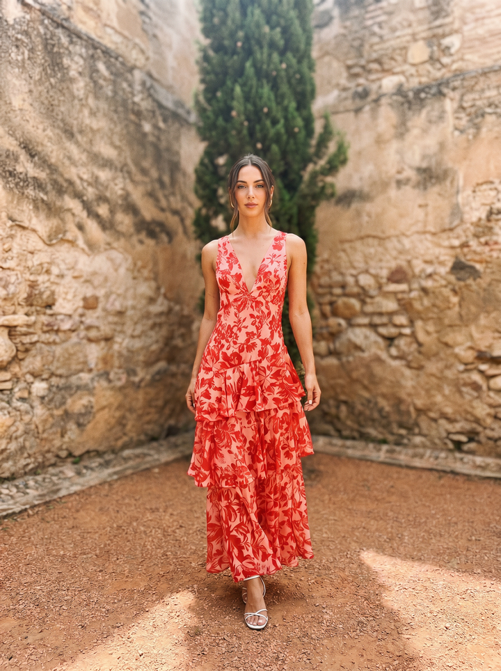 Floral print dress with deep V-neck by Emma & Rose Cape Town, shown on a model with flowing fabric and vibrant pattern.